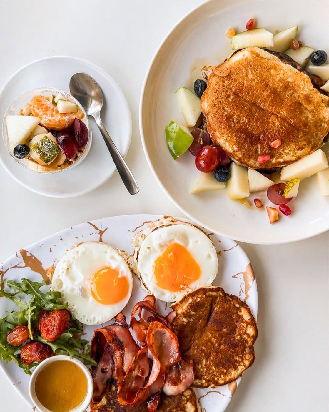 Brunch con pancakes, huevos y fruta fresca